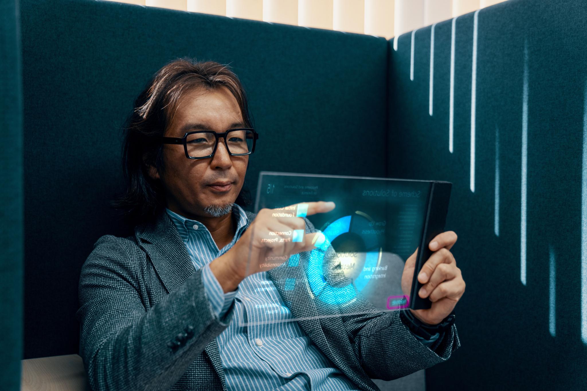 Mid adult businessman using futuristic AI tablet computer